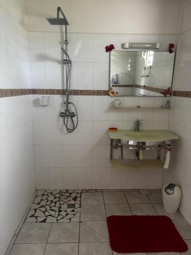 a bathroom with a sink and a mirror at Cerise in Sainte-Anne