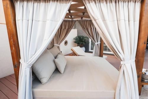 a bedroom with a canopy bed with curtains at TULUM luxury suites-SKOPJE in Skopje
