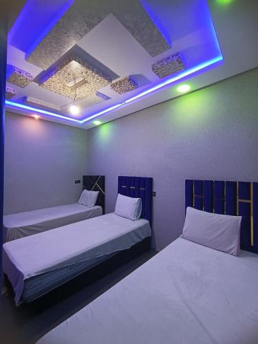 a room with two beds and a blue light at Toubkal Guesthouse in Imlil