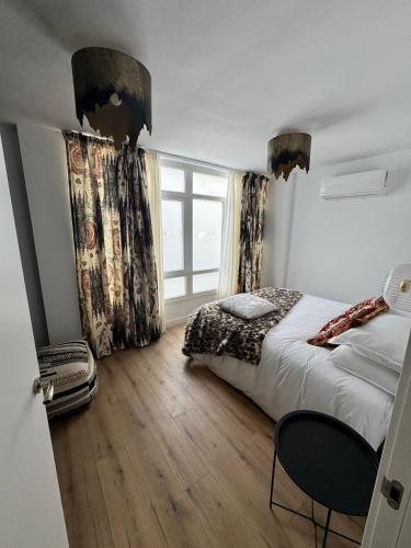 a bedroom with a bed and a window at Diana Boutique Apartamentos in Mérida