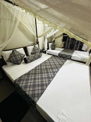 a room with two beds in a tent at The Sigiriya Rock Gate Chalet in Sigiriya