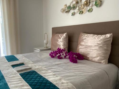 a bed with purple flowers sitting on top of it at Villa ste Catherine in Porto-Vecchio