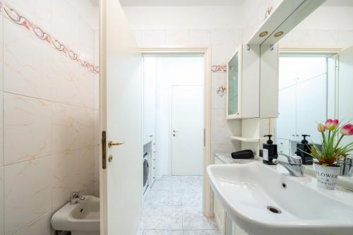 a white bathroom with a sink and a mirror at Lake Como - Front Station - Lake at 2 min - Wifi in Lecco