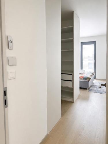 a white room with a bed and a closet at SunsetSkylineApartment in Nivy