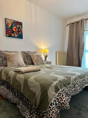 a bedroom with a bed with a cheetah blanket at Escale Rennes in Rennes
