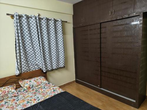 a bedroom with a bed and a large closet at Stayvora Nest in Bangalore