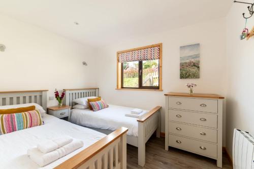 a twin bedroom with two beds and a window at L56 - Seaglass in Truro