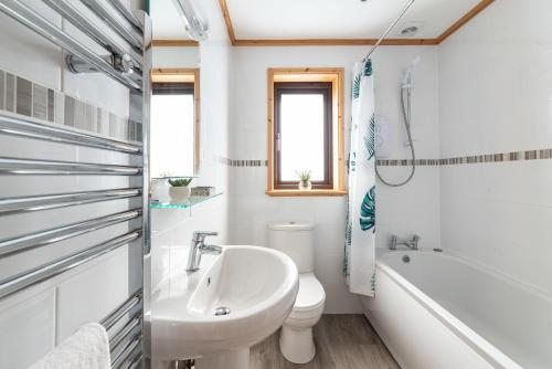 a bathroom with a sink and a toilet and a tub at L56 - Seaglass in Truro