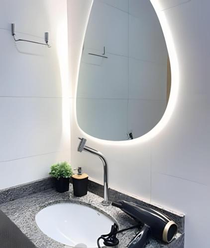 a bathroom with a sink and a mirror at Santorini Urban Studio • conforto e estilo in Londrina