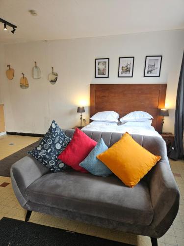a couch with colorful pillows on it in a bedroom at Le 61 Roosvelt in Amiens