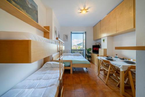 a room with two bunk beds and a table at Vista piste da sci - Aprica Centro - Piste a 2 min, Wifi in Aprica
