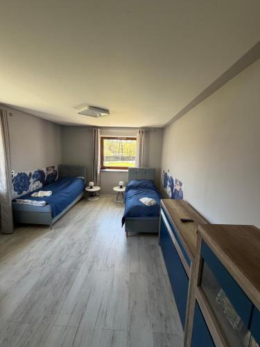 a room with two beds and a table in it at Szlachcianka in Gorzuchów