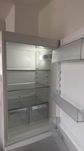 an empty refrigerator with its door open in a kitchen at Ocean View Guesthouse in Borgarnes