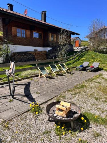 a group of chairs and a fire pit in front of a house at Goldiger Hirsch Pension mit Gemeinschaftsküche in Immenstadt im Allgäu