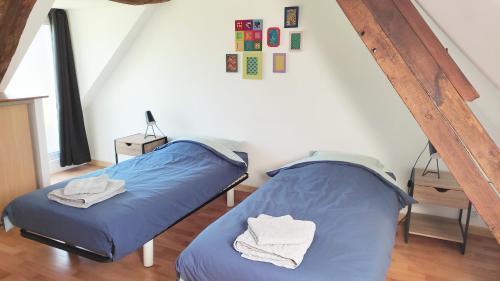 a room with two beds in a attic at Gîte de l'Aubinière in Brissac-Quincé