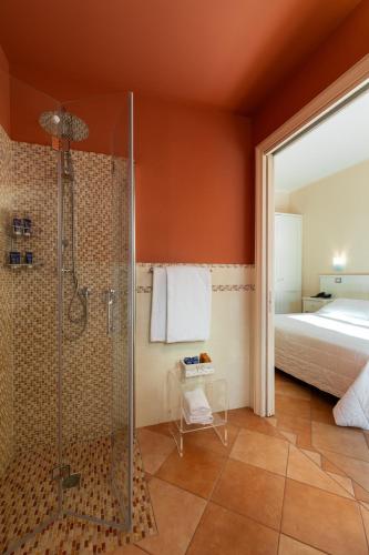 a bathroom with a shower and a bed at Marin Hotel in Pula