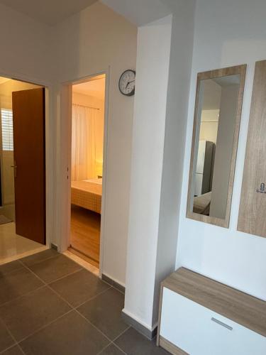 a hallway with a mirror and a bedroom with a bed at Apartment Hramina in Murter