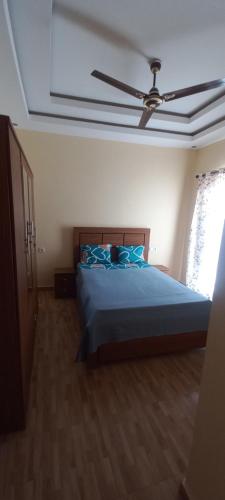 a bedroom with a bed with a ceiling fan at Résidence Diamant in Bamako