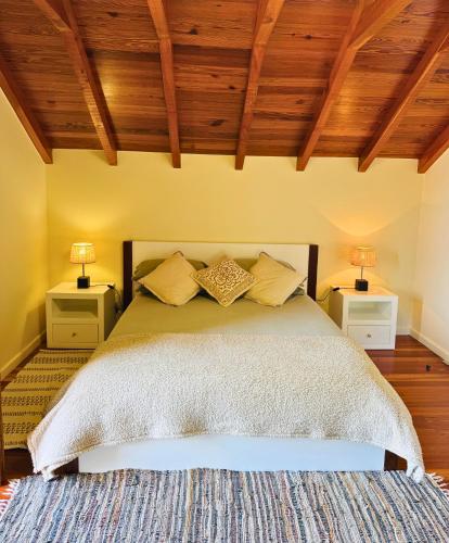a bedroom with a large bed with two night stands at Ribeira da Janela Paradise View in Porto Moniz