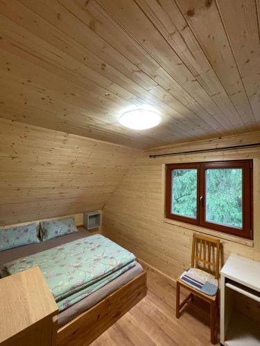 a bedroom with a bed in a wooden cabin at Komorník Residence 14 in Kunžak