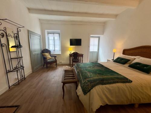 a bedroom with a large bed and a desk at La Maison de Lyon in Saint-Laurent-de-Céris
