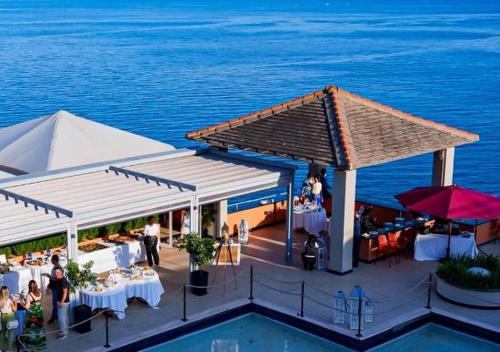 a pavilion with tables and chairs and the water at Hotiday Arenzano Pineta in Arenzano