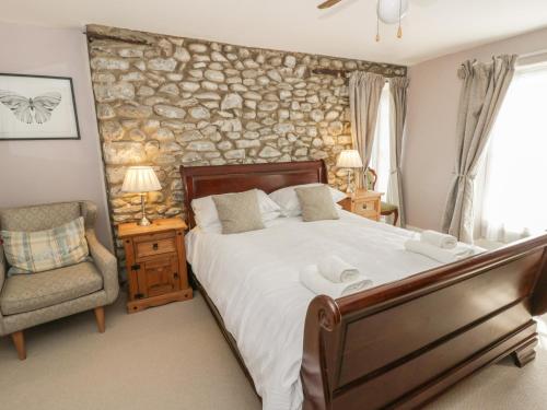 a bedroom with a bed and a stone wall at Dewi Villa in Aberaeron