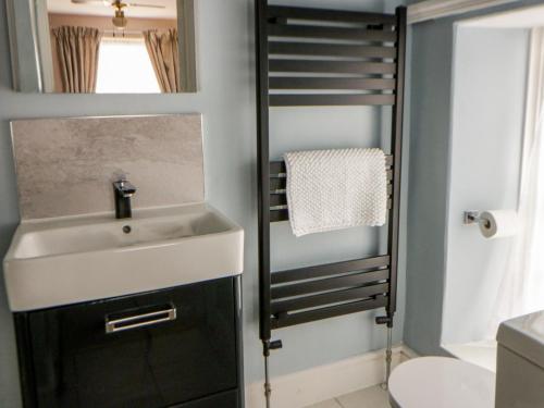 a bathroom with a sink and a mirror at Dewi Villa in Aberaeron