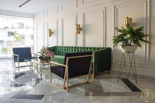 a living room with a green couch and chairs at OR HOTEL 94 in Barranquilla