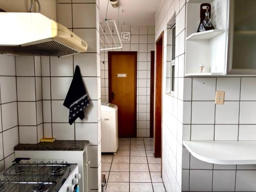 a small kitchen with a stove and a sink at Apartamento Uberlândia - BH in Belo Horizonte