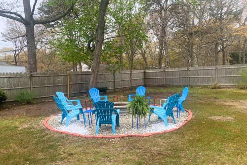 a group of blue chairs around a table in a yard at Dog-Friendly Cape Cod Getaway with Fire Pit Yard in South Yarmouth