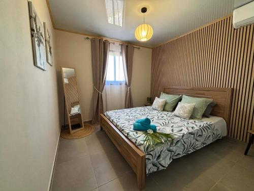 a bedroom with a bed with a blue hat on it at Cap'vanille in Saint-Philippe