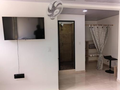 a living room with a television on a wall at Finca hotel el porvenir in Quimbaya