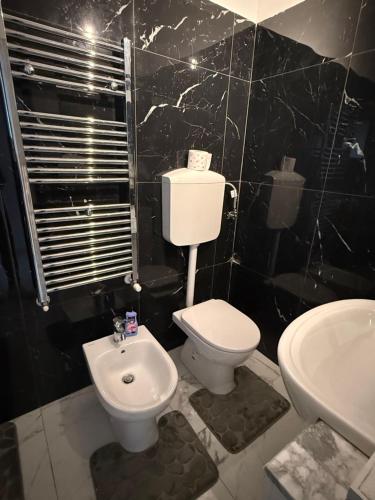 a bathroom with a white toilet and a sink at RK chic Apartments in Colombaro