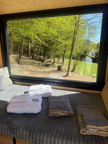 a bed with two towels on it in front of a window at Čiles in Kostolec