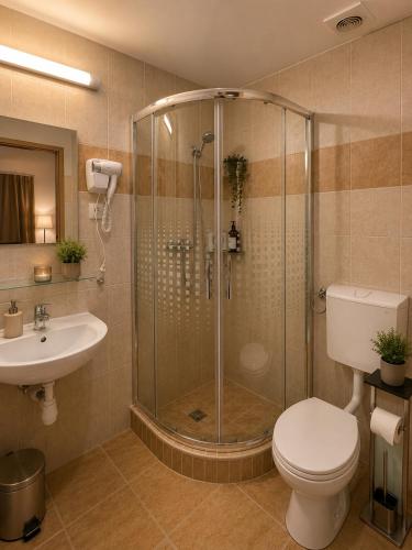 a bathroom with a shower and a toilet and a sink at Esprit Residences Budapest in Budapest