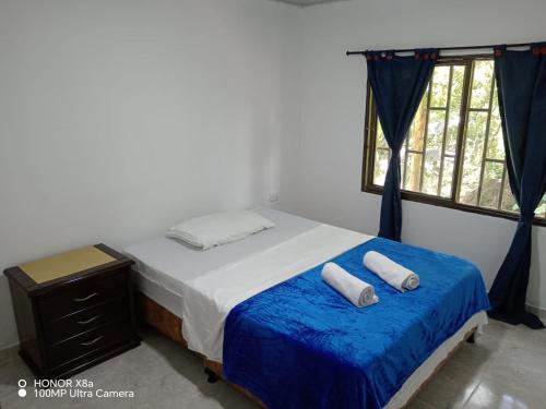 a bedroom with a bed with two towels on it at Finca hotel el porvenir in Quimbaya