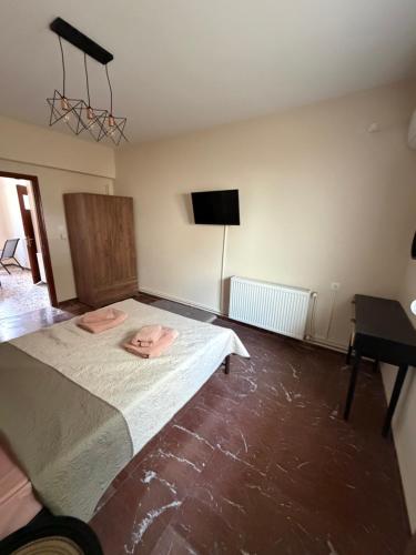 a bedroom with a bed with two pink towels on it at Derveni Nest Apartment in Rodhéa