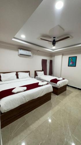 a bedroom with two beds and a ceiling at THE RAMA Executive in Tuljapur
