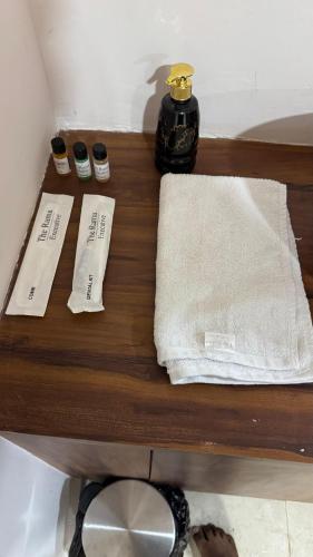 a wooden shelf with two towels and a bottle on it at THE RAMA Executive in Tuljapur