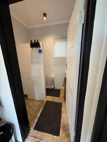a hallway with a white refrigerator in a room at Avo 1 on 27 Drew in Howick
