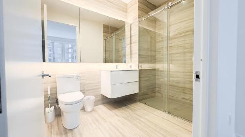 a bathroom with a toilet and a glass shower at Stylish 3BR Luxury Retreat in the Heart of FiDi in New York