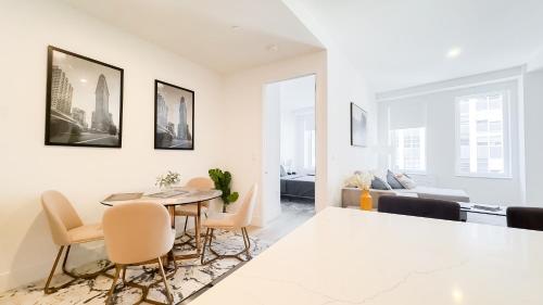 a dining room and living room with a table and chairs at Stylish 3BR Luxury Retreat in the Heart of FiDi in New York