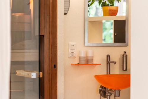 a bathroom with a red sink and a mirror at Ferienstudio Traunsee in Gmunden