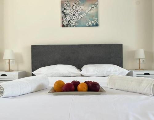 a bed with a tray of fruit on it at Alexandras Studio in Corfu