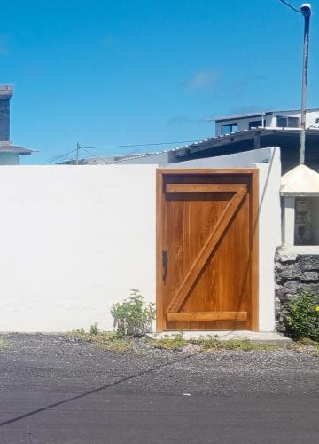 a wooden door on the side of a building at Iguana Marina House in Puerto Villamil