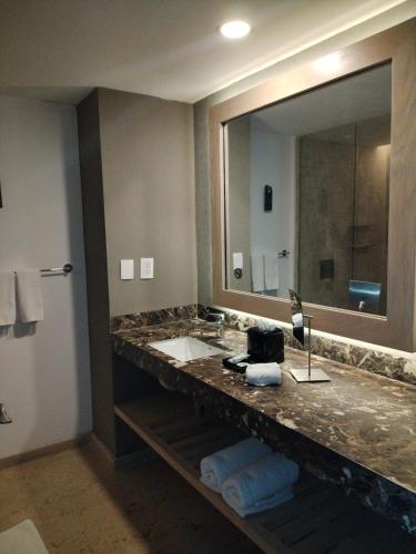 a bathroom with a sink and a large mirror at Courtyard by Marriott Tuxpan Veracruz in Tuxpan de Rodríguez Cano