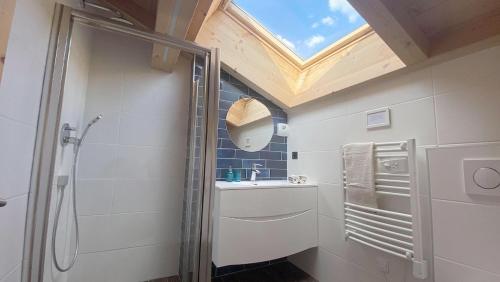 a bathroom with a shower and a sink and a skylight at Chalet Azalée, Montriond, Morzine, Avoriaz in Montriond