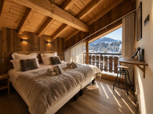 a bedroom with a large bed and a large window at Chalet Azalée, Montriond, Morzine, Avoriaz in Montriond