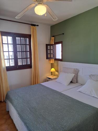 a bedroom with a large bed and two windows at Posidonia -Son Bou Apartment in Son Bou